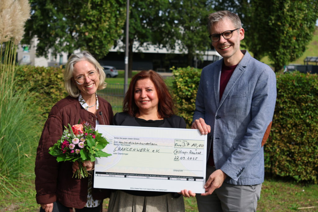 Anne Krüger, Dudu Vural und Jens Langensiepen halten den Spendenscheck in den Händen.