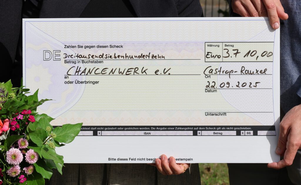 Der Spendenscheck an Chancenwerk über 3.710 Euro wird in Großaufnahme gezeigt.